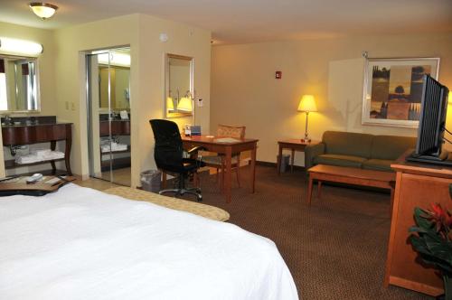 a hotel room with a bed and a couch and a desk at Hampton Inn Clinton in Clinton