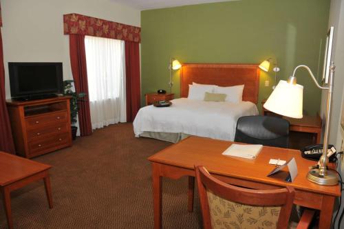 a hotel room with a bed and a desk with a desk at Hampton Inn Clinton in Clinton