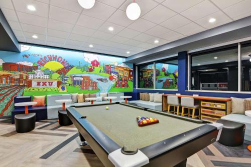 a game room with a pool table and a mural at Tru By Hilton Richmond in Richmond
