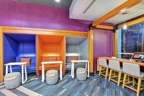 a restaurant with colorful walls and tables and stools at Tru By Hilton Richmond in Richmond