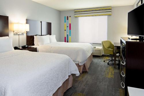 ein Hotelzimmer mit 2 Betten und einem Schreibtisch in der Unterkunft Hampton Inn and Suites Bakersfield / Highway 58 in Bakersfield