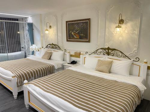 a hotel room with two beds with striped sheets at 玉蘭函館民宿Yulan Hokodate in Datong