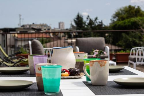 una mesa con tazas y platos de comida. en [Terrazza privata] Venezia Mestre, en Marghera