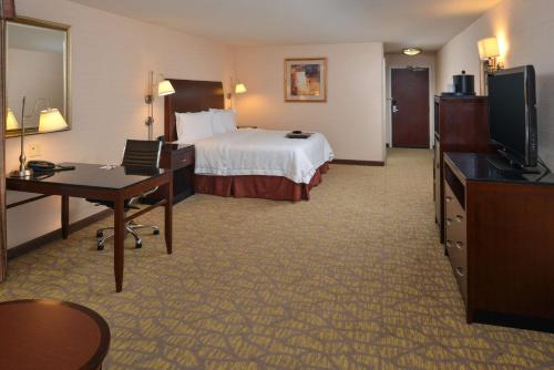 a hotel room with a bed and a desk and a television at Hampton Inn & Suites Tacoma in Tacoma