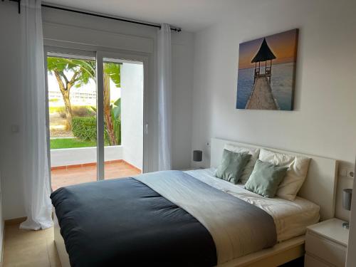 Un dormitorio con una cama grande y una ventana en Las Terrazas De La Torre Golf Resort, en Las Pedreñas
