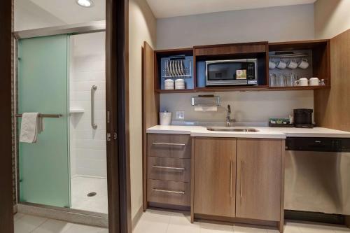 uma pequena cozinha com um lavatório e um micro-ondas em Home2 Suites By Hilton Charlotte Uptown em Charlotte