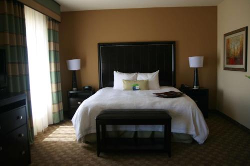 a hotel room with a large bed and a window at Hampton Inn & Suites McAlester in McAlester