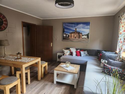 ein Wohnzimmer mit einem Sofa und einem Tisch in der Unterkunft Ferienwohnung Salut in Saarbrücken