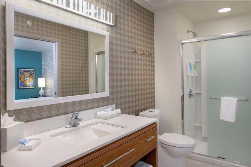 a bathroom with a sink and a toilet and a mirror at Home2 Suites St. Louis / Forest Park in Richmond Heights