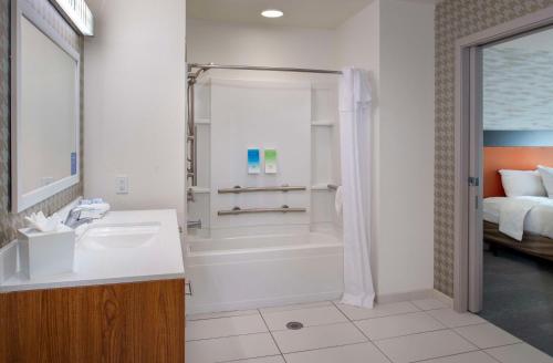 a bathroom with a tub and a sink and a shower at Home2 Suites St. Louis / Forest Park in Richmond Heights