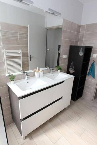 une salle de bain avec un lavabo blanc et un miroir dans l'établissement Maison climatisée avec parking, à Montauban