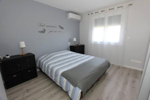 une chambre blanche avec un lit et une fenêtre dans l'établissement Maison climatisée avec parking, à Montauban