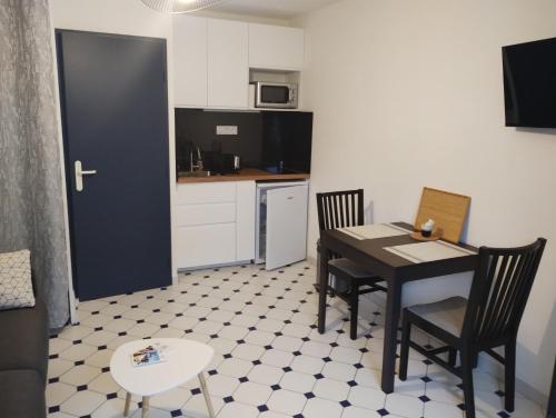 une cuisine et une salle à manger avec une table et des chaises dans l'établissement Studio plain pied avec terrasse tout proche mer, à Courseulles-sur-Mer