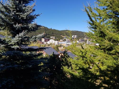a view of a town from between trees at chalet près des pistes avec vue panoramique in Les Angles