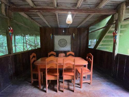 a wooden dining room with a wooden table and chairs at Stay at the river house in Iquitos