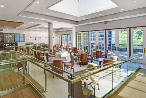 a restaurant with tables and chairs and windows at Hilton Peachtree City Atlanta Hotel & Conference Center in Peachtree City