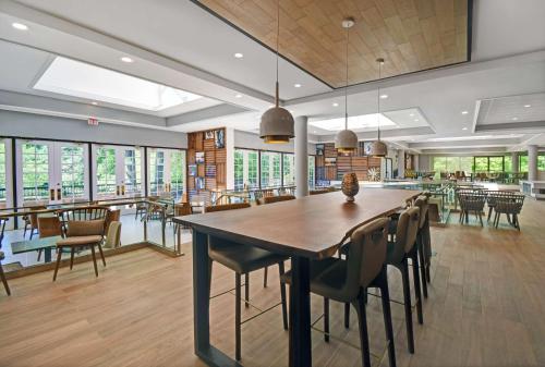 a dining room with a large wooden table and chairs at Hilton Peachtree City Atlanta Hotel & Conference Center in Peachtree City