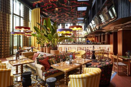 un restaurant avec des tables et des chaises et un bar dans l'établissement Mama Shelter Dijon, à Dijon