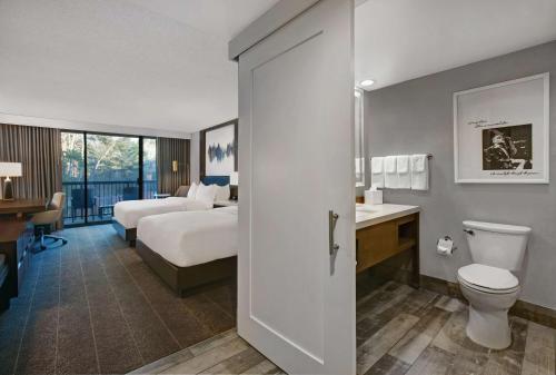 a hotel room with a bed and a toilet and a bathroom at Hilton Peachtree City Atlanta Hotel & Conference Center in Peachtree City