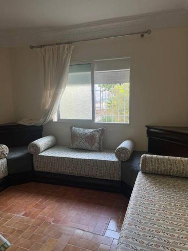 uma sala de estar com um sofá e uma janela em Appartement hay el fath résidence calme propre em Rabat