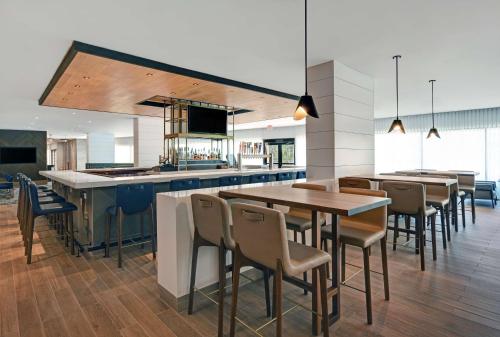 a restaurant with tables and chairs and a kitchen at Hilton Peachtree City Atlanta Hotel & Conference Center in Peachtree City