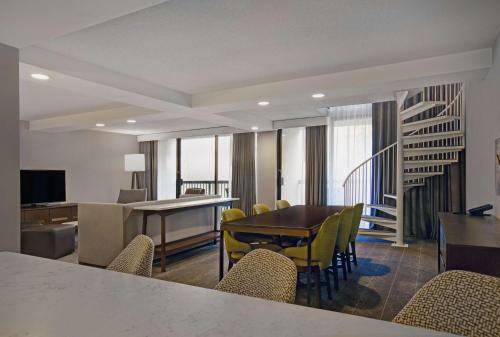 a living room with a dining room table and chairs at Hilton Peachtree City Atlanta Hotel & Conference Center in Peachtree City
