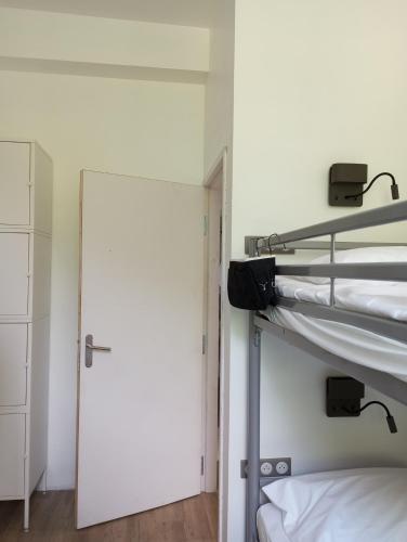 穆瓦薩克的住宿－Gîte Comme une parenthèse，带两张双层床和一扇门的房间
