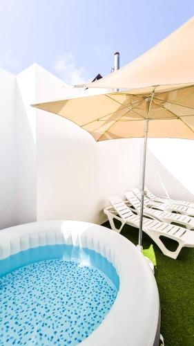 a hot tub in a room with an umbrella at Atypicap Capsule Hostel in Puerto de la Cruz