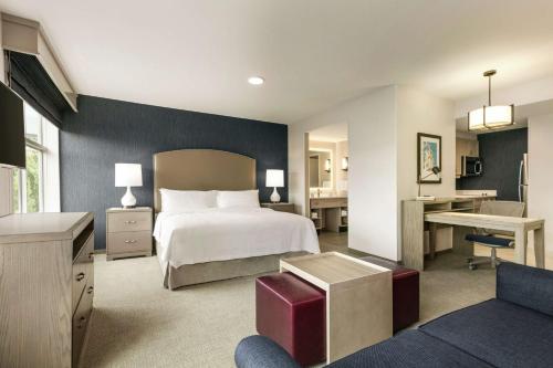 ウースターにあるHomewood Suites By Hilton Worcesterのベッドとデスクが備わるホテルルームです。