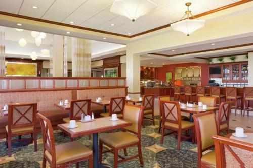 a restaurant with tables and chairs and a bar at Hilton Garden Inn Shreveport in Shreveport