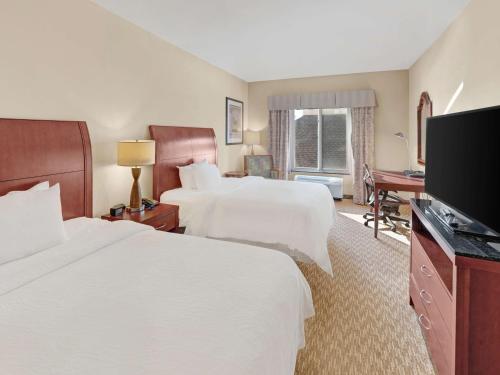 a hotel room with two beds and a flat screen tv at Hilton Garden Inn Oklahoma City North Quail Springs in Oklahoma City
