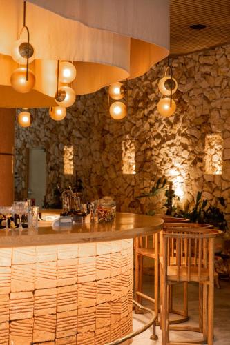 a kitchen with a bar with a stone wall at 23 Hotel Medellin in Medellín