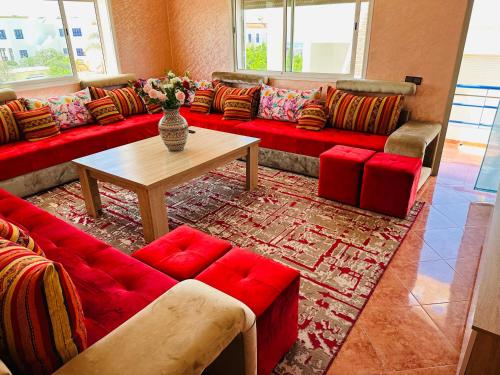a living room with a red couch and a table at Oualidia29 in Oualidia