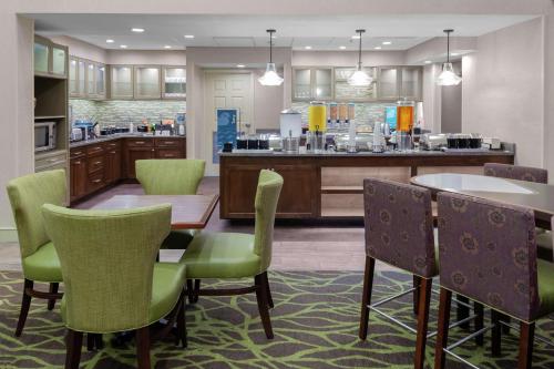 a kitchen with a table and chairs and a counter at Homewood Suites by Hilton Tallahassee in Tallahassee