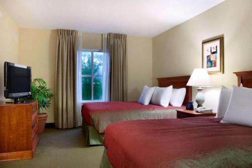 ein Hotelzimmer mit 2 Betten und einem TV in der Unterkunft Homewood Suites by Hilton Tallahassee in Tallahassee