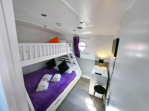 a small bedroom with a bunk bed and a tv at The Joker Boat in Liverpool