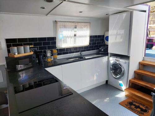 a kitchen with a sink and a washing machine at The Joker Boat in Liverpool