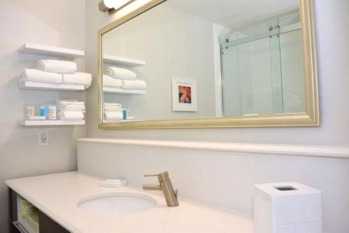 a bathroom with a sink and a mirror and towels at Hampton Inn Grand Junction in Grand Junction