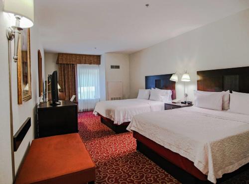 a hotel room with two beds and a flat screen tv at Hampton Inn Kingston in Kingston