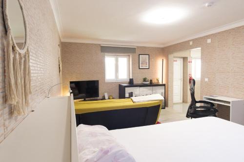 ein Schlafzimmer mit einem Bett und einem Schreibtisch in einem Zimmer in der Unterkunft Perafita Yellow House - EcoHostPT in Perafita
