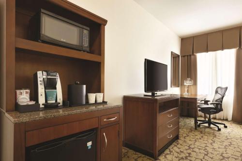 a hotel room with a television and a desk with a chair at Hilton Garden Inn Rochester Downtown, NY in Rochester