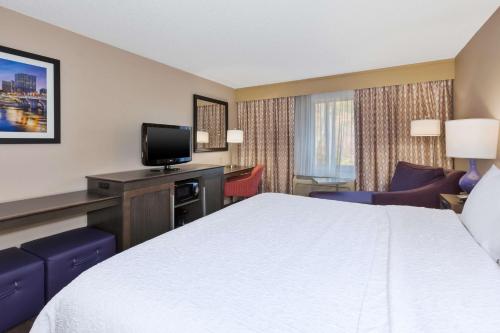 a hotel room with a bed and a tv at Hampton Inn Waterbury in Waterbury