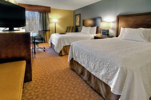 a hotel room with two beds and a flat screen tv at Hampton Inn Jonesville/Elkin in Arlington