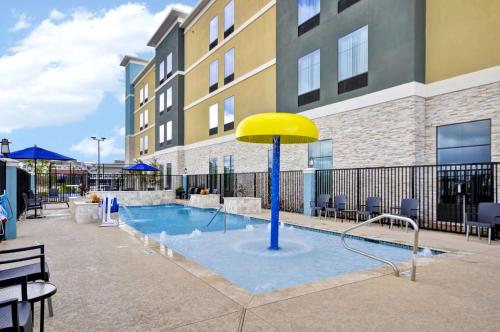a pool with a yellow umbrella in the middle of a building at Homewood Suites by Hilton New Braunfels in New Braunfels
