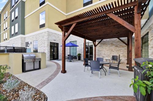 a patio with a wooden pergola and a table and chairs at Homewood Suites by Hilton New Braunfels in New Braunfels