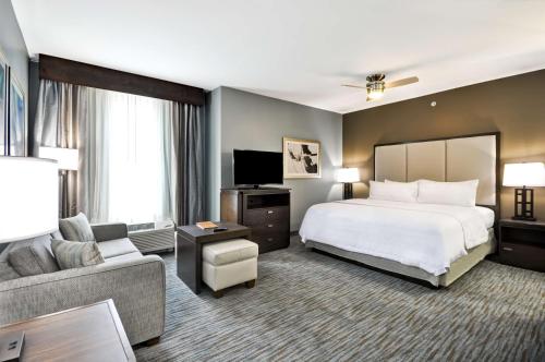 a large hotel room with a bed and a couch at Homewood Suites by Hilton New Braunfels in New Braunfels