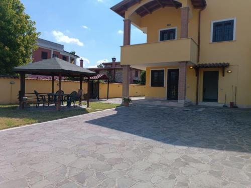 a house with a patio and a table and umbrella at Cottage OstiaAntica in Ostia Antica