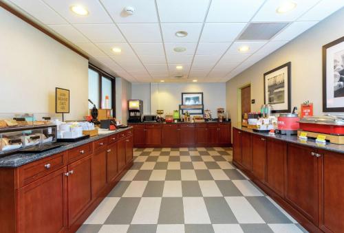 eine große Küche mit Holzschränken und einem Schachbrettboden in der Unterkunft Hampton Inn & Suites - Fort Pierce in Fort Pierce