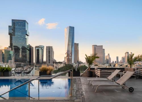 een balkon met een zwembad en een skyline van de stad bij Jo Shtibel Tel-Aviv in Tel Aviv