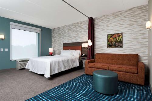 a hotel room with a bed and a couch at Home2 Suites By Hilton Roswell, Ga in Roswell